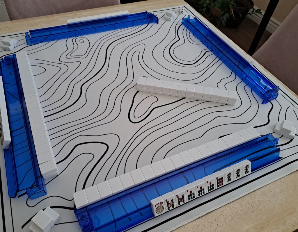 Three Mah Jongg tiles stacked in a pyramid formation to represent the second left pass during the Charleston phase in American Mahjong.