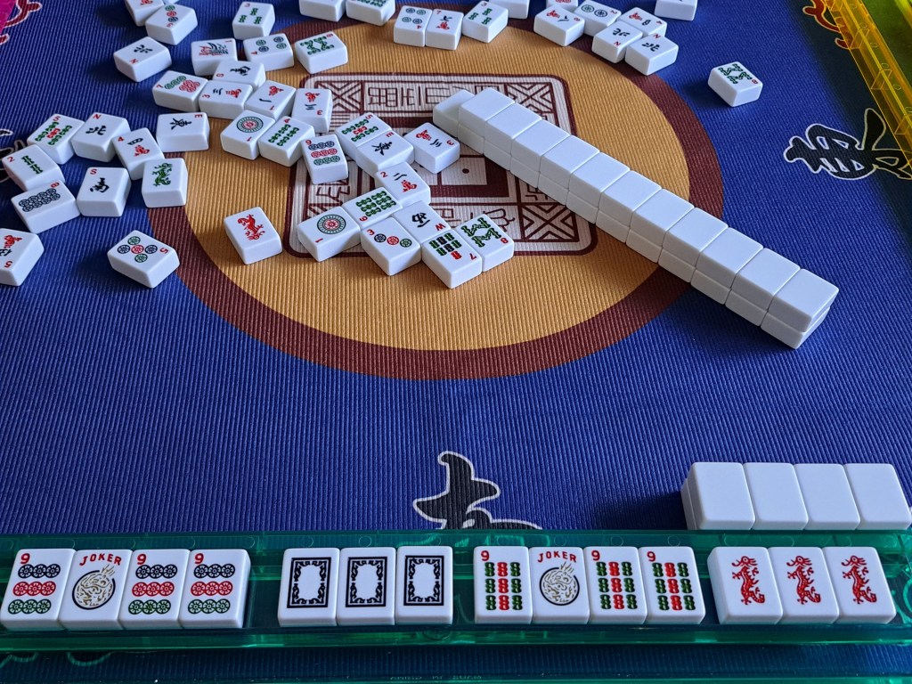 American Mahjong hand showing two kongs of 9s, one in dots and one in bams, with red dragons that do not match the 9 bams suit and make the hand invalid.