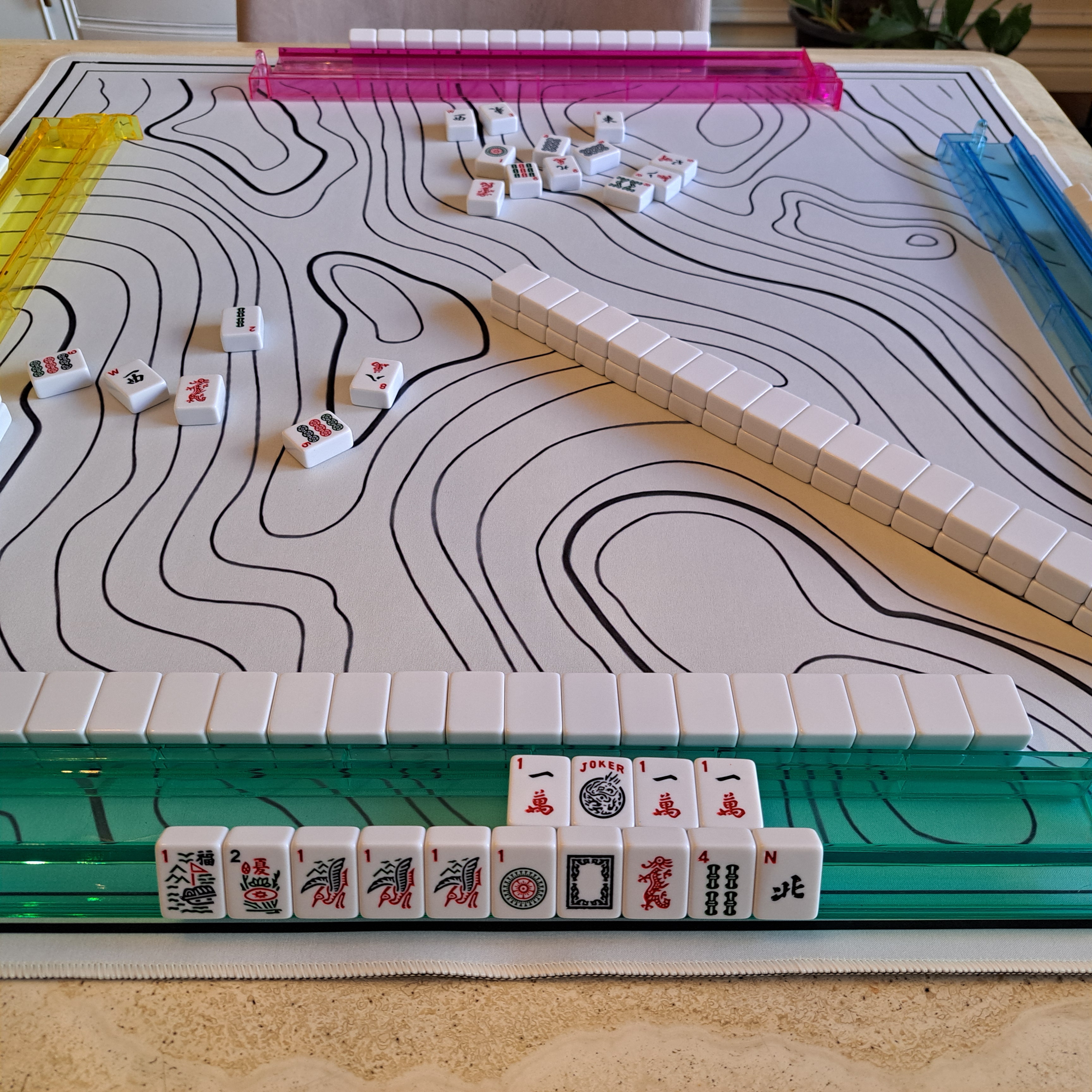 Exposure of three One Craks and a joker displayed on a Mahjong rack, illustrating how players reveal part of their hand during American Mahjong gameplay.