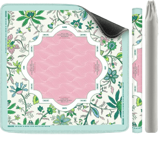 A colorful rectangular yoga mat with a floral design and a pink center, partially rolled up, accompanied by a matching carrying strap.